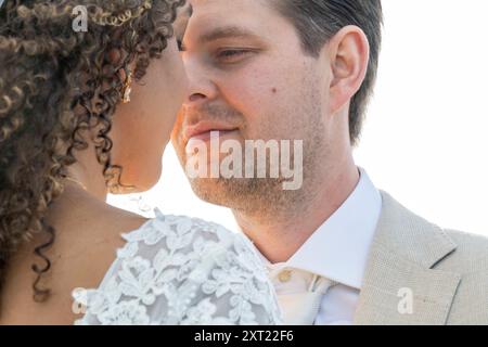 Intimer Moment zwischen einer Braut mit lockigen Haaren und einem Bräutigam in einem beigen Anzug, mit Gesichtern nahe beieinander. Panc05982 Copyright: XConnectxImagesx Stockfoto