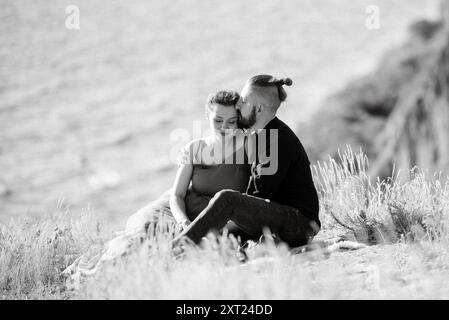 Schwangere Frau und Freund auf hohen Hügeln in der Nähe des Meeres Stockfoto