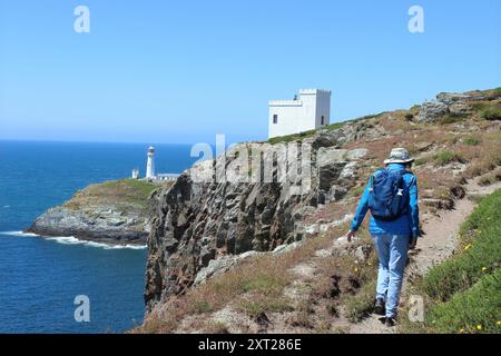 Wandern Sie auf dem Anglesey Coastal Path in der Nähe des Elin's Tower (Tŵr Elin), mit dem Leuchtturm South Stack in der Ferne Stockfoto