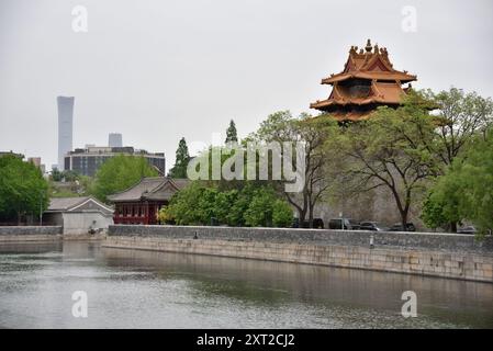 Nordöstlicher Turm der Verbotenen Stadt, umgeben vom Wassergraben, mit Wolkenkratzern des Central Business District im Hintergrund, in Peking Stockfoto