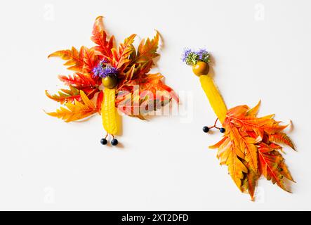 Bunte Feenfiguren aus Blättern und Blumen, herbstliches Handwerk, diy-Ideen, Cepativity, orangener Pfau Stockfoto