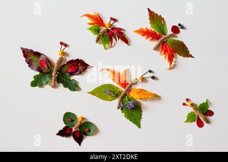 Farbenfrohe Feenfiguren aus Blättern und Blumen, herbstliches Handwerk, diy-Ideen, Zetternative, bunte Schmetterlinge Stockfoto