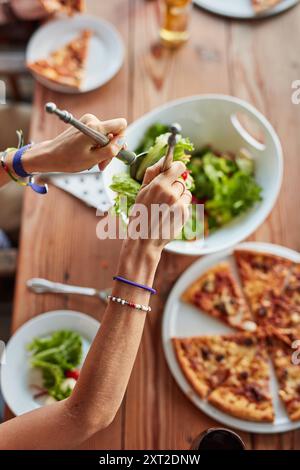 Hände, Salat und Pizza im Restaurant mit Draufsicht für Brunch, Geburtstag und Feierlichkeiten im Freien. Gruppe von Personen, Essen und Bier oder Glas bei Stockfoto