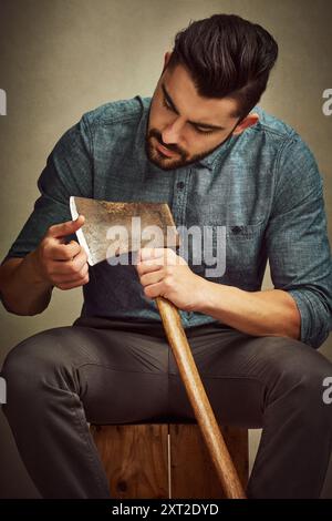 Mann, Holzfäller und Axt mit Klinge oder Waffe für Holz, Hacken oder männliche Aktivität auf einem Studiohintergrund. Gutaussehender oder junger männlicher Mensch im Retro Stockfoto