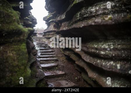 Schmaler Steinweg, der sich durch Felsformationen schlängelt, die in einer natürlichen abgeschiedenen Umgebung nach oben führen Stockfoto