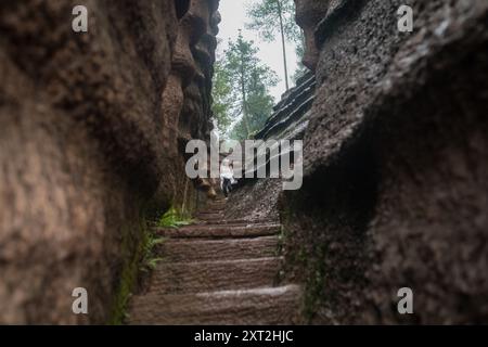 Schmaler Steinweg, der sich durch Felsformationen schlängelt, die in einer natürlichen abgeschiedenen Umgebung nach oben führen Stockfoto