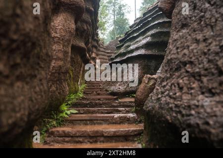 Schmaler Steinweg, der sich durch Felsformationen schlängelt, die in einer natürlichen abgeschiedenen Umgebung nach oben führen Stockfoto