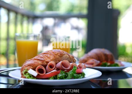 Leckere Croissant-Sandwiches auf weißem Hintergrund. Croissant mit Fleisch. Frühstück Croissant Sandwiches serviert Holzbrett Stockfoto