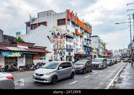 Der Verkehr fährt an einem großen, farbenfrohen Wandgemälde an der Seite eines weißen Gebäudes in der Chulia Street in Little India, George Town, Penang, Malaysia vorbei Stockfoto