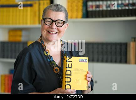 Berlin, Deutschland. August 2024. Kathrin Kunkel-Razum, Chefredakteurin des Duden, hält den neuen Duden des Jahres 2024 in Händen. Quelle: Jens Kalaene/dpa/Alamy Live News Stockfoto