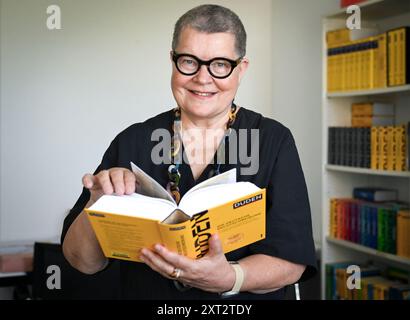 Berlin, Deutschland. August 2024. Kathrin Kunkel-Razum, Chefredakteurin des Duden, hält den neuen Duden des Jahres 2024 in Händen. Quelle: Jens Kalaene/dpa/Alamy Live News Stockfoto