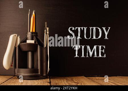 Ein Bleistifthalter mit Bleistift, Stift und Radiergummi auf schwarzem Hintergrund mit den Worten Study Time in weiß geschrieben Stockfoto