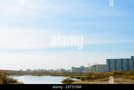 Panorama mit Fluss und Natur und Wohnhochhäusern in der Ferne Stockfoto