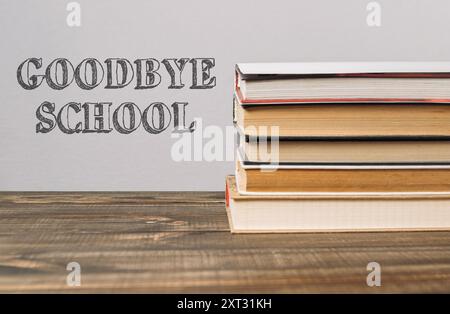 Ein Stapel Bücher mit dem Wort "Goodbye School". Die Bücher stapeln sich übereinander, wodurch ein Gefühl von Bedeutung und Bedeutung entsteht Stockfoto