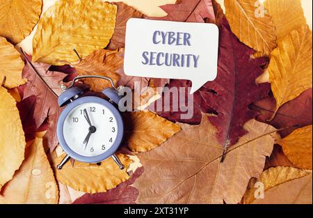 Eine Uhr steht auf einem Stapel Blätter mit den Worten Cyber Security darunter. Konzept der Bedeutung der Cybersicherheit und der Notwendigkeit, V Stockfoto