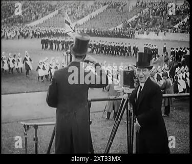 Männliche Newsreel Kamerabediener mit Stativen und Ausrüstung, 1920er Jahre "...die britische Empire-Ausstellung in London 1924 - das war die große Demonstration von Einheit und Ressourcen, die zur Förderung der Solidarität des Imperiums und zur Förderung des Handels genutzt wurden. So großartig waren einige seiner Funktionen, dass viele Kameramänner in Spitzenhüten und Morgenkleidern auftauchten, um ihre Griffe zu drehen. Aus „Time to Remember – Come the Dawn“, 1925 (Reel 3); werfen Sie einen Blick auf die britische Filmindustrie der 1920er Jahre – Clips aus großen Stummfilmen und Wochenschauen. Stockfoto