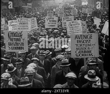 Amerikanische Antifaschisten marschieren und halten Schilder, 1933. Menschen protestieren gegen die Verfolgung der Juden durch die Nazis: „Zertrümmern Sie die Rückkehr des Kaiserismus in Deutschland; rächen Sie faschistische Folter und Mord an deutschen Arbeitern; lange lebe der Kampf des deutschen Proletariats“. Überall auf der Welt, wo es große jüdische Gemeinden gab, gab es Demonstrationen, Proteste, und nirgendwo wurden Stimmen höher als in den Vereinigten Staaten erhoben. Aber nur Worte werfen keinen Tyrannen um. Aus „Time to Remember – The Time of the Monster“, 1933 (Reel 4); ein Dokumentarfilm über Ereignisse von 1933, Stockfoto