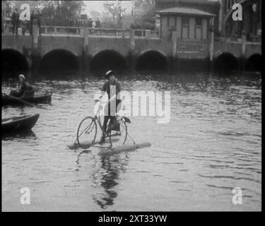 Frau, die auf einem schwimmenden Fahrrad entlang eines Flusses reitet, 1920. „Die Frauen hatten ihre Behinderungen im Sattel und ihre Füße auf den Pedalen, und es gab kein Hindernis für sie.“ Aus "Time to Remember - the Plunge into Peace", 1920 (Reel 3); Ereignisse von 1920 - Hochzeiten, Frauenrechte, industrielle Unruhen und Probleme in Irland Stockfoto