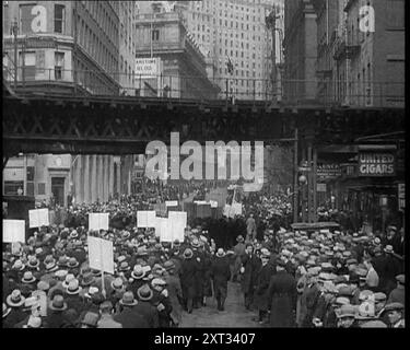 Menschenmenge, die eine Straße entlang läuft und Schilder hält, 1933. Menschen protestieren gegen die Verfolgung von Juden durch die Nazis. Überall auf der Welt, wo es große jüdische Gemeinden gab, gab es Demonstrationen, Proteste, und nirgendwo wurden Stimmen höher als in den Vereinigten Staaten erhoben. Aber nur Worte werfen keinen Tyrannen um. Aus „Time to Remember – The Time of the Monster“, 1933 (Reel 4); ein Dokumentarfilm über die Ereignisse von 1933, Rise of Roosevelt und Hitler. Stockfoto