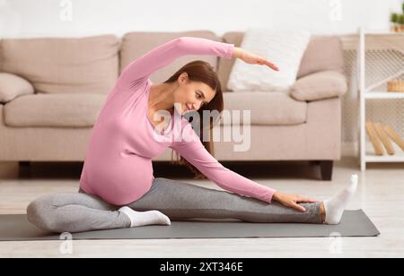 Ruhe schwangere Frau zu tun Stretching Übungen zu Hause Stockfoto