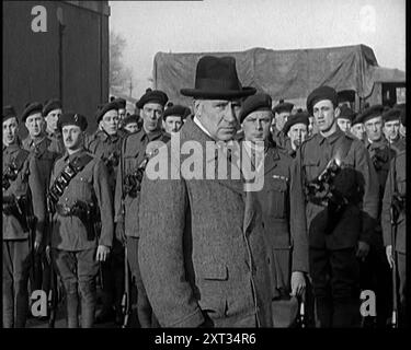 Ein britischer Mann, der die Linien irischer Hilfssoldaten inspiziert und mit ihnen spricht, 1921. Aus "Time to Remember - The Time When Little Happened", 1921 (Reel 2); Ereignisse von 1921 - Irish treaty, Mad Stunts and Newspapers at Work. Stockfoto