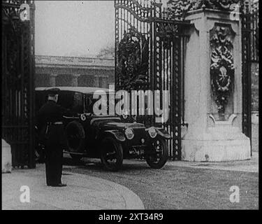 Ein uniformierter männlicher und ein männlicher britischer Polizist stehen vor den Toren des Buckingham Palace, als ein Auto durchfährt, 1924. Aus "Time to Remember - A Trip to Europe", 1924 (Rolle 2); ein Blick auf das politische und soziale Leben in Europa und darüber hinaus im Jahr 1924. Stockfoto