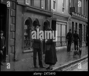 Menschen, die auf einer verlassenen Straße in Irland laufen, 1921. Aus "Time to Remember - The Time When Little Happened", 1921 (Reel 2); Ereignisse von 1921 - Irish treaty, Mad Stunts and Newspapers at Work. Stockfoto