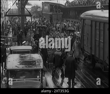 Mohandas K Gandhi (Mahatma) Spaziergang entlang der Docks, 1931. In einen britischen Hafen segelte jemand, dessen Kleidung und Verhalten ihn zur am meisten verbreiteten Figur der Zeit machten. In London wurde ein Rundtischgespräch einberufen, um die heiklen Probleme Indiens und ihre Forderungen nach Selbstbestimmung in Frieden zu regeln. In London erschien also das lebendige Symbol von unzähligen Millionen, Mahatma Gandhi. Aus „Time to Remember – A New Era“, 1931 (Reel 1); Dokumentarfilm über die Welt in den frühen 1930er Jahren Stockfoto