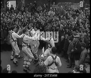 Eine Menschenmenge, die Morris-Tänzerinnen beim Auftritt zusieht, 1931. Volkstänze. Ja, so mancher Dorfplatz und Saal klang mit "sammeln der Peascods", "Sweet Kate", "Black Nag" und vielen anderen zeitlosen alten Lüften. Ja, für Tausende von Jung und Alt, könntest du deinen Ballsaal behalten und deinen Jazz, und sie um das Maypole wickeln. Aus „Time to Remember – A New Era“, 1931 (Reel 2); Dokumentarfilm über die Welt in den frühen 1930er Jahren Stockfoto