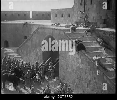 Szene aus einem Film: Schauspieler, die britische Truppen beim Sturmen einer Festung spielen, während die Toten und Sterbenden um sie herum liegen, 1920er Jahre "Das Fort in Umballa [Ambala], über das die Flagge immer noch flog, der Name des Films spielt keine Rolle, aber eine mutige Anklage brachte diese Situation bald in Ordnung, marschierte in die entlastete Festung, nur um unter den Trümmern nur noch einen Verteidiger zu finden, der am Leben geblieben ist, und den einen, nur einfach." Aus „Time to Remember – Come the Dawn“, 1925 (Reel 3); werfen Sie einen Blick auf die britische Filmindustrie der 1920er Jahre – Clips aus großen Stummfilmen und Wochenschauen. Stockfoto