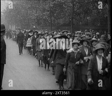 Markante Tea Shop Ladies, die die Straße hinuntermarschieren, flankiert von der Polizei, 1920. Frauen gehen während des Bergarbeiterstreiks raus. '...being in der Zeit der weiblichen Emanzipation waren auch Damen manchmal in Waffen. Teeshop-Kellnerinnen protestierten gegen die unfaire Behandlung einer ihrer Leute. Es gab einen Mangel an Tassen Tee und Kohle. Aus "Time to Remember - the Plunge into Peace", 1920 (Reel 2); Ereignisse von 1920 - Hochzeiten, Frauenrechte, industrielle Unruhen und Probleme in Irland Stockfoto