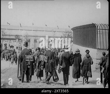 Männliche Newsreel Kamerabediener mit Stativen und Ausrüstung, 1920er Jahre "...die britische Empire-Ausstellung in London 1924 - das war die große Demonstration von Einheit und Ressourcen, die zur Förderung der Solidarität des Imperiums und zur Förderung des Handels genutzt wurden. So großartig waren einige seiner Funktionen, dass viele Kameramänner in Spitzenhüten und Morgenkleidern auftauchten, um ihre Griffe zu drehen. Aus „Time to Remember – Come the Dawn“, 1925 (Reel 3); werfen Sie einen Blick auf die britische Filmindustrie der 1920er Jahre – Clips aus großen Stummfilmen und Wochenschauen. Stockfoto