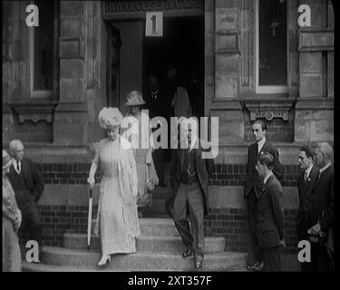 Königin Mary begleitet von einer Gruppe von Beamten, die aus einem Gebäude kamen, 1924. Aus "Time to Remember - A Trip to Europe", 1924 (Rolle 2); ein Blick auf das politische und soziale Leben in Europa und darüber hinaus im Jahr 1924. Stockfoto