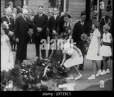 Junge Mädchen, die Blumen in einem Stapel für Wilhelmina, Ihre Majestät die Königin der Niederlande, 1930er Jahre Aus „Time to Remember – the Powers that WHO WE“, 1930er Jahre (Walze 1); ein Dokumentarfilm über verschiedene wichtige Figuren der 1930er Jahre Stockfoto