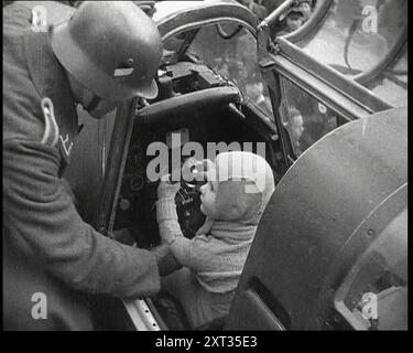 Ein junger Junge, der im Cockpit eines Kampfflugzeugs sitzt, 1930er Jahre Aus "Time to Remember - the Powers that WHO WE", 1930er Jahre (Walze 3); ein Dokumentarfilm über verschiedene wichtige Figuren der 1930er Jahre Stockfoto