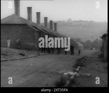 Männliche Zivilisten stehen auf den Straßen vor ihren Häusern, 1926. Aus „Time to Remember 1926 – Short Sharp Shower“ (Reel 4); Dokumentarfilm über 1926 – General Strike, internationale Politik, Tanz, Wetter und rekordbrechende Meisterleistungen. Stockfoto