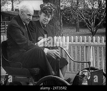 Henry und Clara Ford sitzen in einem alten Auto, 1921. Aus "Time to Remember - The Time When Little Happened", 1921 (Reel 3); Ereignisse von 1921 - Irish treaty, Mad Stunts and Newspapers at Work. Stockfoto