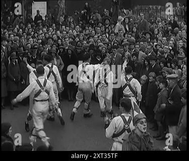 Eine Menschenmenge, die Morris-Tänzerinnen beim Auftritt zusieht, 1931. Volkstänze. Ja, so mancher Dorfplatz und Saal klang mit "sammeln der Peascods", "Sweet Kate", "Black Nag" und vielen anderen zeitlosen alten Lüften. Ja, für Tausende von Jung und Alt, könntest du deinen Ballsaal behalten und deinen Jazz, und sie um das Maypole wickeln. Aus „Time to Remember – A New Era“, 1931 (Reel 2); Dokumentarfilm über die Welt in den frühen 1930er Jahren Stockfoto