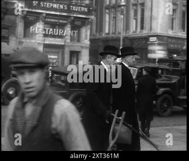 Zwei männliche Politiker gehen entlang einer belebten Bridge Street in Richtung Palace of Westminster, 1937. Staatsmänner kümmerten sich um [Großbritanniens] Geschäfte, und es gab genug für sie. Denn die Welt außerhalb Großbritanniens war die Krönung von 1937 ruhelos, sich ständig wandelnd, bedrohlich und voller Zweifel und Ängste." Aus "Time to Remember - Sense of Values", 1937 (Reel 1); Dokumentarfilm über die Ereignisse von 1937, Krieg im Fernen Osten, Aufbau bis Krieg in Europa. Stockfoto