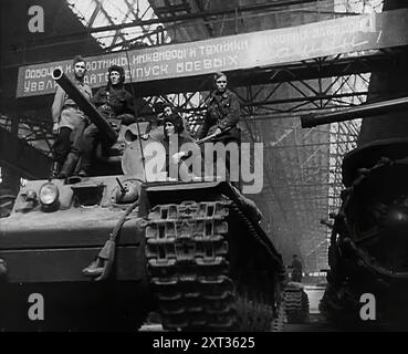 Ein russischer Panzer wird aus einer Fabrik vertrieben, 1941. Zweiter Weltkrieg. Russland widersetzt sich der Invasion durch Nazi-Deutschland. "Ein Schärfen der Klauen für den Bären, der sich nicht hinlegen wollte." Aus „Time to Remember – Operation Barbarossa“, 1941 (Reel 4); Dokumentarfilm über Ereignisse von 1941, an der Ostfront und in Pearl Harbour. Stockfoto