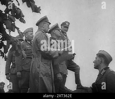 Deutsche Offiziere und Soldaten, 1941. Zweiter Weltkrieg. Operation Barbarossa war die Invasion der Sowjetunion durch Nazi-Deutschland. "...mehr als hundert Divisionen warteten an der Grenze des geteilten Polens, bereit, sich auf Befehl des Führers zu stürzen... die 24 Divisionen umleiteten, um Griechenland und Jugoslawien zu erobern, zogen zurück, um ihre richtigen Stationen für den Angriff auf Russland einzunehmen." Aus „Time to Remember – Operation Barbarossa“, 1941 (Reel 2); Dokumentarfilm über Ereignisse von 1941, an der Ostfront und in Pearl Harbour. Stockfoto