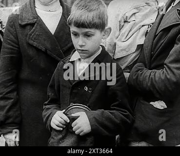 Ein russisches Kind, 1941. Der zweite Weltkrieg: Die Belagerung Leningrads. Operation Barbarossa war die Invasion der Sowjetunion durch Nazi-Deutschland. "Eine Stadt leidet unter allem, was eine Stadt erleiden konnte, aber weigert sich, nachzugeben, obwohl drei Teile umzingelt sind... Ein toter Bär, der sich nicht nur weigert, sich hinzusetzen, sondern tatsächlich seine Klauen benutzt. In ihrer Qual fand Russland unter Stalin, wie Russland einst unter Alexander, wieder den leidenschaftlichen Mut eines Volkes, das sein Land liebte." Aus „Time to Remember – Operation Barbarossa“, 1941 (Reel 3); Dokumentarfilm über Ereignisse von 1941, an der Ostfront und A Stockfoto