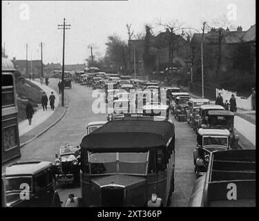 Autos, die eine Straße zur Kamera hinunterfahren, 1930er Jahre Aus "Time to Remember - Some People in the Thirties", 1930er Jahre (Rolle 1); Dokumentarfilm über die 1930er Jahre, der sich auf berühmte Charaktere dieser Zeit konzentriert. Stockfoto