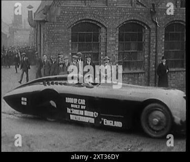 Sir Henry Segrave, auch bekannt als Major Segrave, fährt 'Sunbeam' aus einer Fabrik, beobachtet von einer Menschenmenge Zivilisten, 1927. Segrave’s 1000 PS Sunbeam Car „Mystery“ (auch bekannt als „The Slug“), in dem er am 29. März 1927 einen neuen Weltrekord von 203,79 km/h am Daytona Beach in Florida aufstellte. Aus "Time to Remember - Fast and Far in the zwanziger Jahre", 1927 (Rolle 1); ein Blick auf die Besessenheit von Geschwindigkeit und Reisen in den späten 1920er Jahren Stockfoto