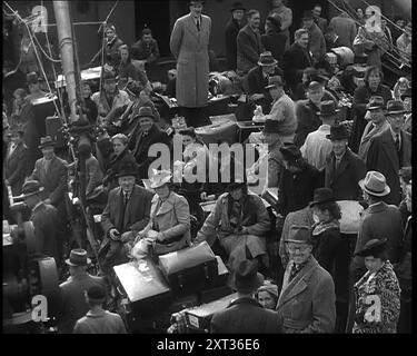 Niederländische Flüchtlinge auf der Flucht an Bord von Schiffen in den Niederlanden, 1940. Zweiter Weltkrieg. "Wichtig und unwichtig - sie kamen nach Großbritannien. Die Verfolgten, die Unschuldigen, die Juden, die Katholiken, die Protestanten, die unerwünschten, die Ungläubigen an die bösen Mächte, die sind. Aber für diejenigen, die noch frei sind, gibt es keine größeren Verbündeten als diejenigen, die die Knechtschaft kennen und ihre Ketten verlassen haben." Aus Time to Remember - Run Rabbit Run, 1940 ( Reel 2); Dokumentarfilm über Ereignisse der frühen Monate 1940. Stockfoto