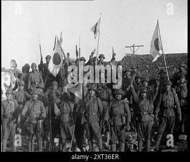 Eine Gruppe männlicher japanischer Soldaten, viele winkende Kanonen Aloft und einige mit japanischer Flagge, die ihre Eroberung Hankows 1937 feierten. Japanische Invasion Chinas. Vor Hankow donnern die japanischen Geschütze in die alten Befestigungsanlagen. Die Vergangenheit geht vor einer neuen und schrecklichen Vorstellung von der Zukunft ein. Die Vorstellung, dass die Macht Recht hat, und die Erde wird von den Starken geerbt werden... mit dem Fall Hankows huldigen die Eroberer den Glauben, der sie in ihre Kriege trieb. Während die Nationalhymne gespielt wird, stehen sie der Richtung des Mikado-Palastes in Tokio gegenüber. Stockfoto