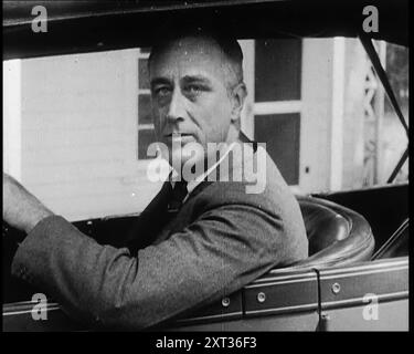 Franklin Delano Roosevelt, zukünftiger Präsident der Vereinigten Staaten, in einem Auto, 1932. "Ein Land von grenzenlosem Reichtum, aber gefangen von seiner Unfähigkeit, diesen Reichtum allen zugänglich zu machen. Es war an der Zeit, dass jemand von irgendwo kommt und etwas tut. Aus „Time to Remember – Around the Corner“, 1932 (Reel 2); Tagebuch der Ereignisse 1932 in den Vereinigten Staaten von Amerika – Franklin Roosevelt wird Präsident. Stockfoto