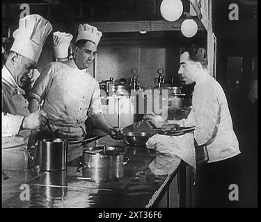 Eine Galley mit Küchenpersonal, das kocht und Kellner mit Geschirr an Bord des Kreuzfahrtschiffes „Kraft durch Freude“, Robert Ley, 1939. Aus „Time to Remember – The Reluctant Warriors“, 1939 (Reel 1); Dokumentarfilm über Ereignisse von 1939 – Vorbereitungen für den Krieg und dann Feindseligkeiten brechen aus. Stockfoto