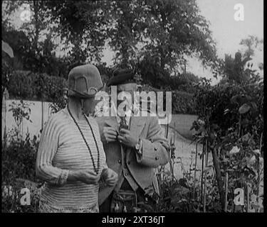 Sir Harry Lauder schenkt Blumen seiner Frau Lady Ann Lauder, zu Hause in Schottland, 1920er Jahre Aus „Time to Remember – On Stage in the Twenties“, 1927 (Rolle 1); ein Blick hinter die Kulissen des Theaters in den 1920er Jahren Stockfoto