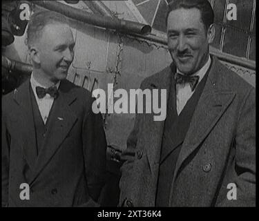 Clarence Duncan Chamberlin und Bertrand Blanchard Acosta sprechen vor einem Flugzeug, 1920er Jahre Im April 1927 stellten die US-amerikanischen Piloten Clarence Chamberlin (links) und Bert Acosta einen Ausdauerrekord für einen Flug auf und blieben 51 Stunden, 11 Minuten und 25 Sekunden in ihrem Wright-Bellanca WB-2 Eindecker Miss Columbia in der Luft. Später im selben Jahr absolvierte Chamberlin den zweiten erfolgreichen Nonstop-Flug von Amerika auf das europäische Festland und den ersten, der einen Passagier beförderte. Aus „Time to Remember – Fast and Far in the Twenties“, 1927 (Rolle 3); ein Blick auf die Besessenheit mit Stockfoto